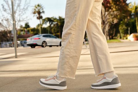 Eine Frau geht mit Turnschuhen auf der Stra?e